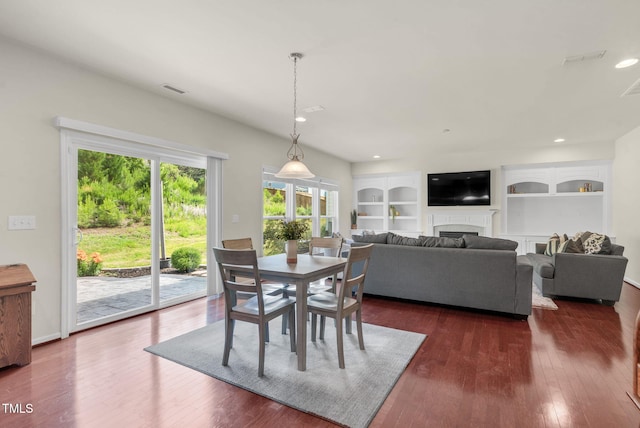 106 Elmsford St, Durham, NC 27703 - dining space featuring dark wood-type flooring, built in shelves, a fireplace, and recessed lighting