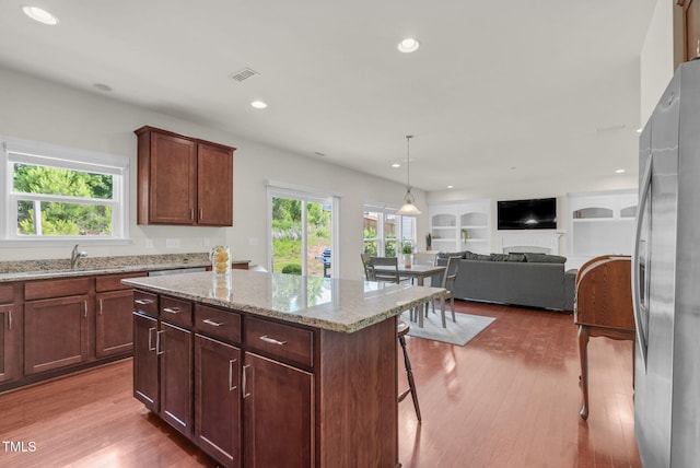 106 Elmsford St, Durham, NC 27703 - kitchen with freestanding refrigerator, healthy amount of natural light, wood finished floors, light stone counters, and recessed lighting