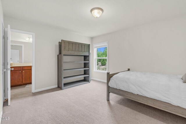 106 Elmsford St, Durham, NC 27703 - bedroom featuring baseboards, light colored carpet, and connected bathroom