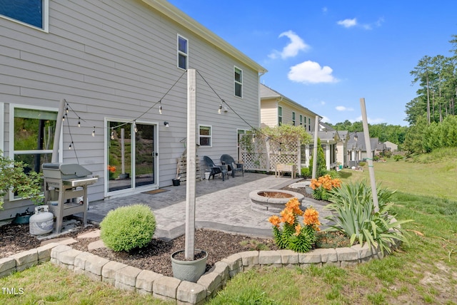 106 Elmsford St, Durham, NC 27703 - back of property with an outdoor fire pit, a patio area, and a lawn