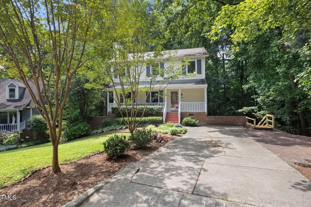 905 Balmoral Dr, Cary, NC 27511 - view of front facade featuring covered porch, brick siding, a front lawn, and driveway