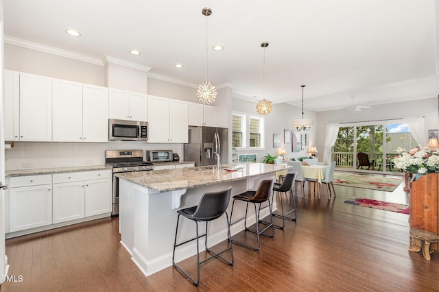 47 Coventry Ln, Chapel Hill, NC 27516 - kitchen with stainless steel appliances, a kitchen island with sink, decorative backsplash, crown molding, and white cabinets