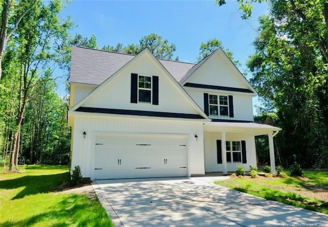 2312 Smith Rd, Hope Mills, NC 28348 - view of front of property with driveway, a front yard, a garage, and a porch