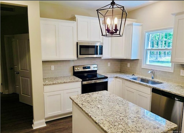 2312 Smith Rd, Hope Mills, NC 28348 - kitchen with appliances with stainless steel finishes, a chandelier, dark wood-style floors, a sink, and white cabinetry