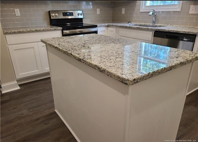2312 Smith Rd, Hope Mills, NC 28348 - kitchen featuring appliances with stainless steel finishes, a sink, dark wood-type flooring, tasteful backsplash, and white cabinetry