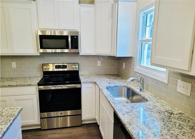 2312 Smith Rd, Hope Mills, NC 28348 - kitchen with appliances with stainless steel finishes, a sink, white cabinetry, and decorative backsplash