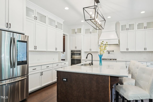 421 Gilpin Way, Cary, NC 27519 - kitchen featuring appliances with stainless steel finishes, a sink, backsplash, dark wood-type flooring, and an island with sink