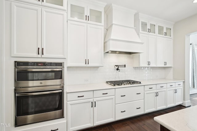 421 Gilpin Way, Cary, NC 27519 - kitchen featuring appliances with stainless steel finishes, custom range hood, dark wood-style flooring, backsplash, and white cabinetry