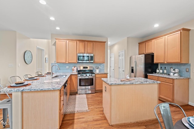 1504 Haventree Rd, Durham, NC 27713 - kitchen featuring stainless steel appliances, a sink, a peninsula, backsplash, and light wood-style floors