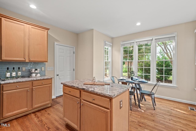 1504 Haventree Rd, Durham, NC 27713 - kitchen featuring light wood finished floors, backsplash, light stone countertops, a kitchen island, and baseboards