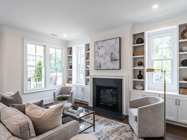 2641 Sidford Aly, Raleigh, NC 27608 - living area featuring ornamental molding, a glass covered fireplace, built in features, dark wood-type flooring, and recessed lighting