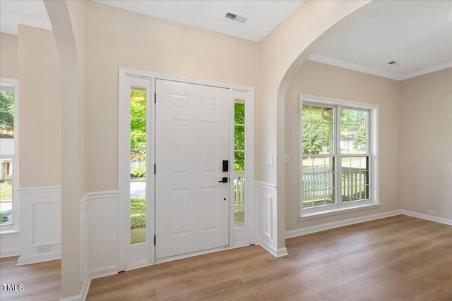121 River Hills Dr, Clayton, NC 27527 - foyer entrance with arched walkways, wood finished floors, plenty of natural light, a wainscoted wall, and crown molding