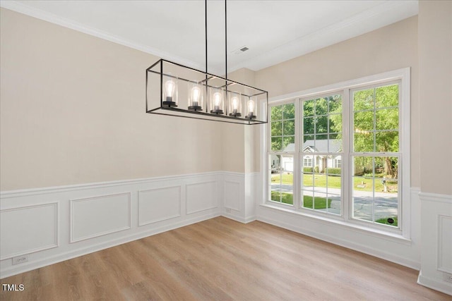 121 River Hills Dr, Clayton, NC 27527 - unfurnished dining area featuring a chandelier, crown molding, light wood-style flooring, wainscoting, and a decorative wall
