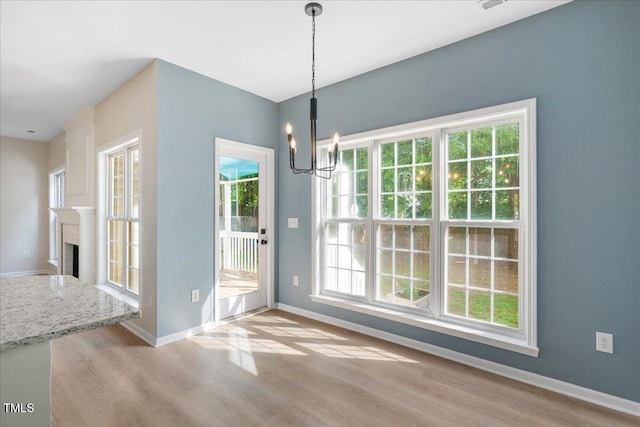 121 River Hills Dr, Clayton, NC 27527 - unfurnished dining area featuring light wood-style floors, a chandelier, healthy amount of natural light, and baseboards