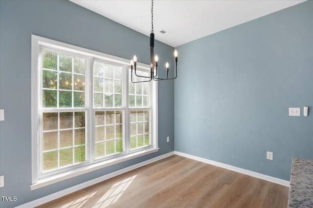 121 River Hills Dr, Clayton, NC 27527 - unfurnished dining area featuring a chandelier, healthy amount of natural light, wood finished floors, and baseboards