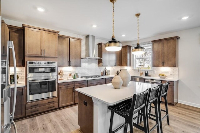 1021 Dillon Lake Dr, Knightdale, NC 27545 - kitchen featuring wall chimney range hood, appliances with stainless steel finishes, a sink, light wood-style floors, and recessed lighting