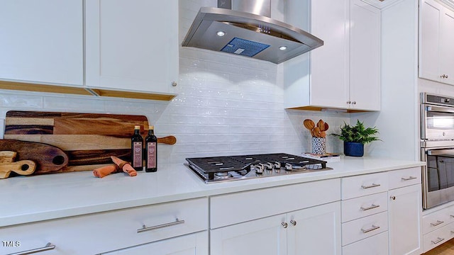 1021 Dillon Lake Dr, Knightdale, NC 27545 - kitchen featuring exhaust hood, appliances with stainless steel finishes, backsplash, white cabinets, and light countertops