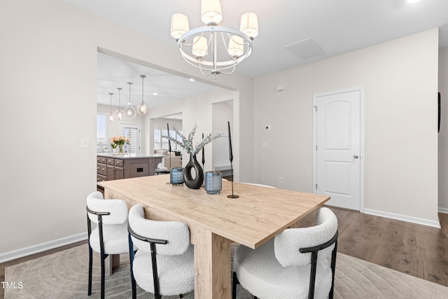 66 Arlie Ln, Lillington, NC 27546 - dining room with a chandelier, dark wood-style flooring, and baseboards