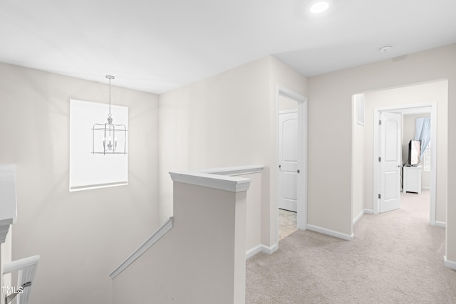 66 Arlie Ln, Lillington, NC 27546 - hall featuring an upstairs landing, light carpet, baseboards, and a chandelier