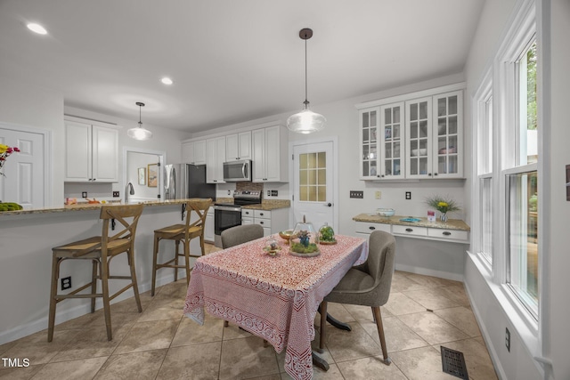 106 Fawley Ct, Cary, NC 27519 - kitchen with appliances with stainless steel finishes, white cabinets, glass insert cabinets, pendant lighting, and a sink