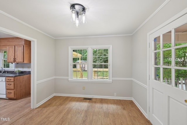 1308 Swallow Dr, Raleigh, NC 27606 - unfurnished dining area with light wood-type flooring, baseboards, a sink, and crown molding