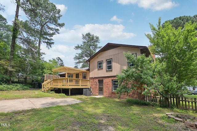 1308 Swallow Dr, Raleigh, NC 27606 - rear view of house featuring a wooden deck, central AC, and brick siding