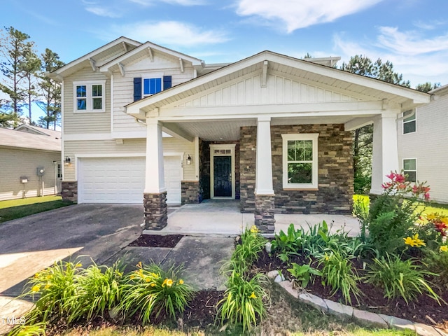 148 Daneborg Rd, Durham, NC 27703 - craftsman-style house featuring driveway, stone siding, covered porch, and a garage