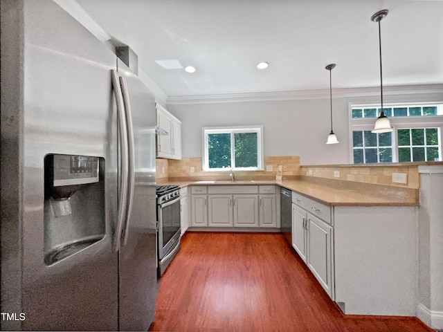 148 Daneborg Rd, Durham, NC 27703 - kitchen with stainless steel appliances, a peninsula, wood finished floors, crown molding, and white cabinets