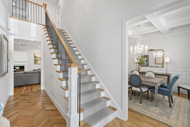911 Canterbury Rd, Raleigh, NC 27607 - stairway with coffered ceiling, a chandelier, a fireplace, beam ceiling, and a ceiling fan