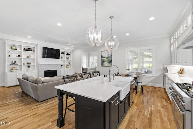 911 Canterbury Rd, Raleigh, NC 27607 - kitchen featuring high end stainless steel range oven, a sink, ornamental molding, a breakfast bar, and a fireplace
