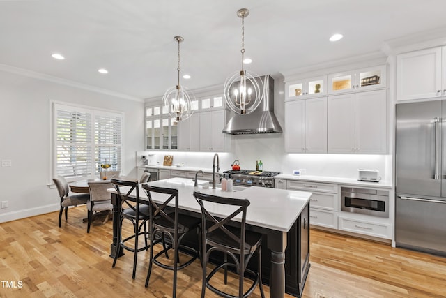 911 Canterbury Rd, Raleigh, NC 27607 - kitchen featuring high end refrigerator, wall chimney range hood, ornamental molding, light countertops, and an island with sink