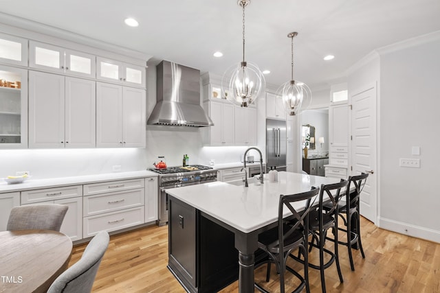 911 Canterbury Rd, Raleigh, NC 27607 - kitchen with wall chimney exhaust hood, premium appliances, a sink, a chandelier, and white cabinetry