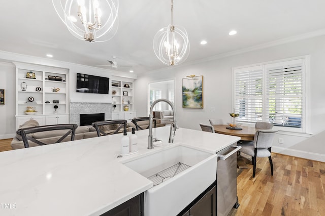 911 Canterbury Rd, Raleigh, NC 27607 - kitchen featuring a chandelier, a sink, a fireplace, ornamental molding, and ceiling fan