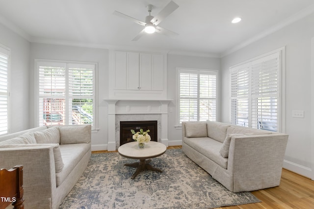 911 Canterbury Rd, Raleigh, NC 27607 - living area featuring light wood-style floors, crown molding, a premium fireplace, baseboards, and a ceiling fan