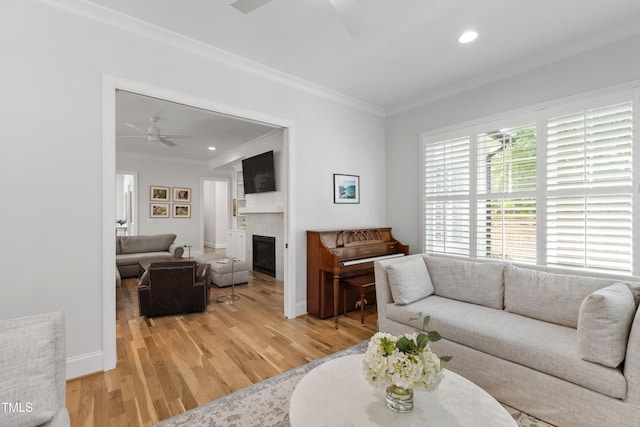 911 Canterbury Rd, Raleigh, NC 27607 - living room with a ceiling fan, crown molding, a glass covered fireplace, light wood-style floors, and recessed lighting