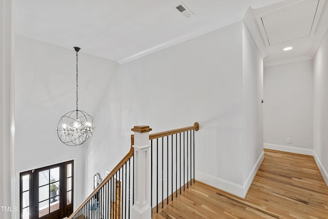 911 Canterbury Rd, Raleigh, NC 27607 - hall with an upstairs landing, light wood finished floors, baseboards, attic access, and ornamental molding
