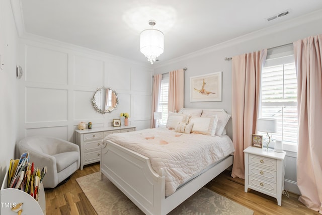 911 Canterbury Rd, Raleigh, NC 27607 - bedroom featuring a decorative wall, crown molding, and wood finished floors