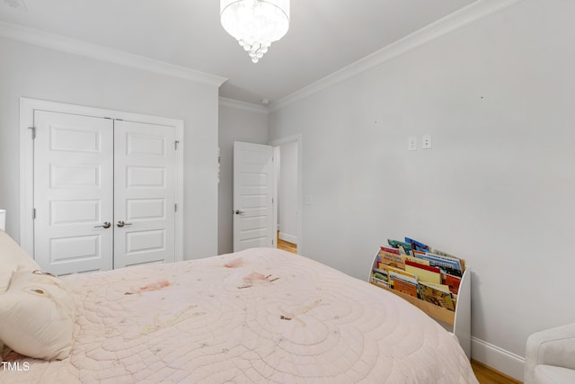 911 Canterbury Rd, Raleigh, NC 27607 - bedroom with ornamental molding, baseboards, wood finished floors, a closet, and a chandelier