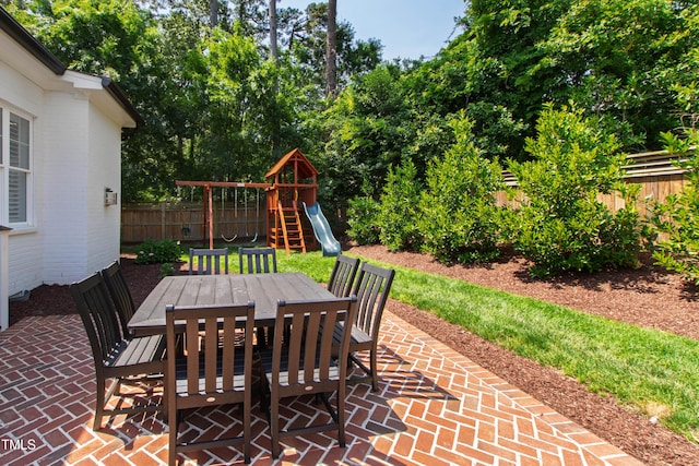 911 Canterbury Rd, Raleigh, NC 27607 - fenced backyard with outdoor dining space, a patio area, and a playground