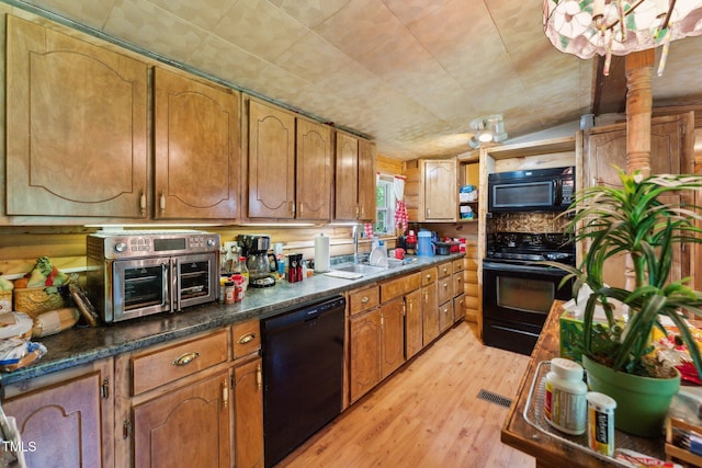 8089 Crawford Currin Rd, Oxford, NC 27565 - kitchen with black appliances, a sink, light wood-style floors, and brown cabinetry