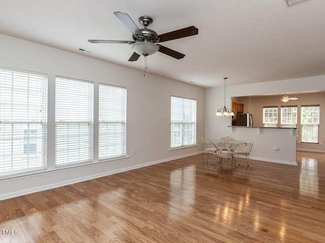 207 Callum Pl, Cary, NC 27519 - unfurnished dining area featuring ceiling fan, light wood-style flooring, baseboards, a chandelier, and healthy amount of natural light