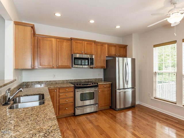 207 Callum Pl, Cary, NC 27519 - kitchen featuring appliances with stainless steel finishes, a sink, brown cabinetry, recessed lighting, and light wood finished floors