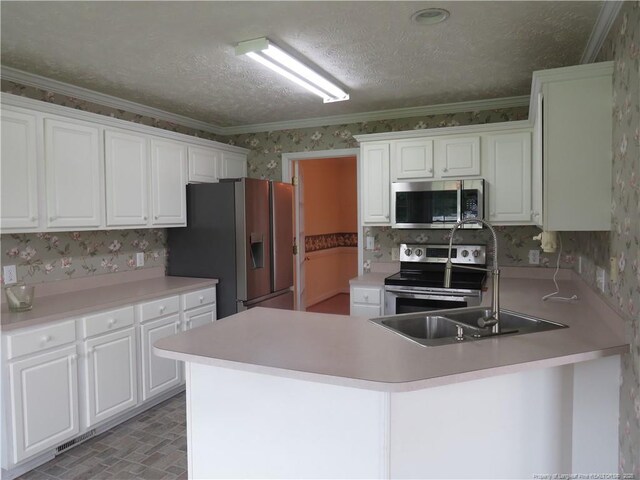 103 Autumn Chase Blvd, Lumberton, NC 28358 - kitchen featuring stainless steel appliances, wallpapered walls, a peninsula, white cabinetry, and a sink