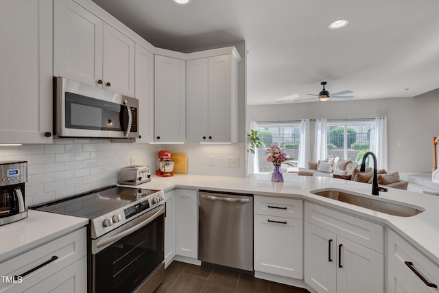 8404 Saltwood Pl, Raleigh, NC 27617 - kitchen featuring appliances with stainless steel finishes, a sink, backsplash, light countertops, and recessed lighting