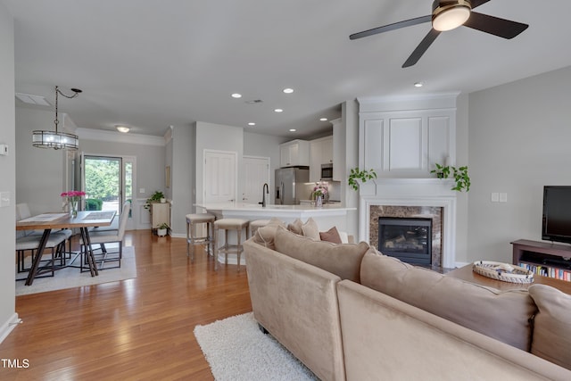 8404 Saltwood Pl, Raleigh, NC 27617 - living room with a ceiling fan, light wood-style flooring, a premium fireplace, recessed lighting, and baseboards