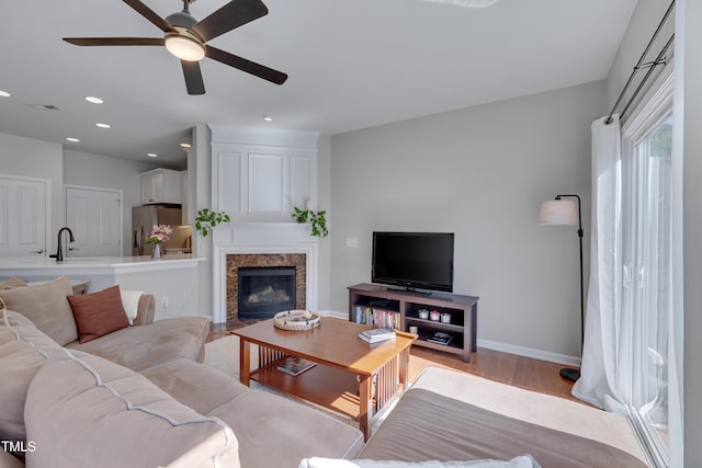 8404 Saltwood Pl, Raleigh, NC 27617 - living room with a ceiling fan, light wood-style flooring, a fireplace with flush hearth, baseboards, and recessed lighting