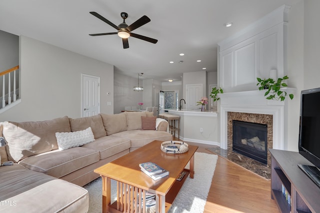 8404 Saltwood Pl, Raleigh, NC 27617 - living area featuring a ceiling fan, light wood finished floors, recessed lighting, a high end fireplace, and stairway