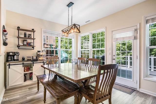 6 Beaver Creek Ln, Durham, NC 27703 - dining space featuring light wood finished floors, a chandelier, and baseboards
