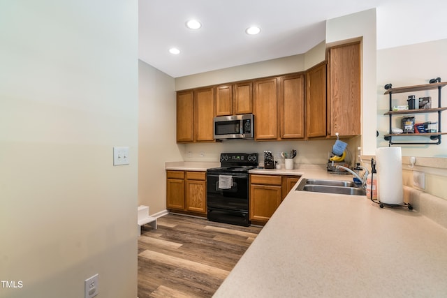 6 Beaver Creek Ln, Durham, NC 27703 - kitchen featuring electric range, stainless steel microwave, a sink, brown cabinets, and light countertops