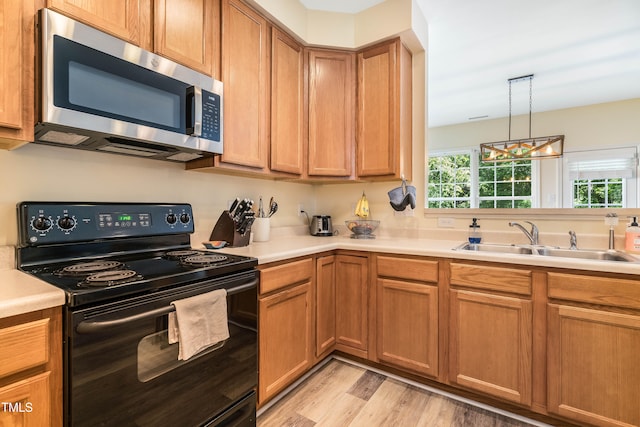 6 Beaver Creek Ln, Durham, NC 27703 - kitchen featuring stainless steel microwave, black electric range oven, a sink, light wood finished floors, and light countertops